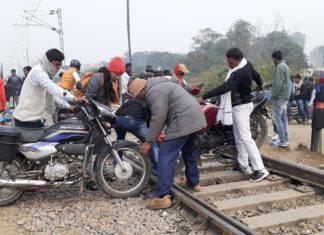 रेलवे फाटक बंद होने के बाद रेलवे ट्रैक पार कर जान जोखिम में डाल रहे लोग