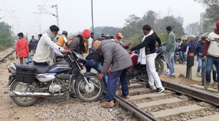 रेलवे फाटक बंद होने के बाद रेलवे ट्रैक पार कर जान जोखिम में डाल रहे लोग